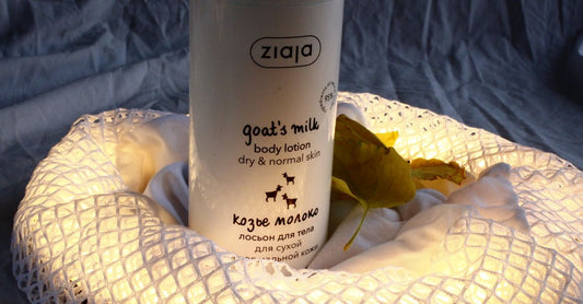 Bottle of goat milk tablets for bone health on a white background, with a few strawberry-flavoured chewable tablets scattered nearby.
