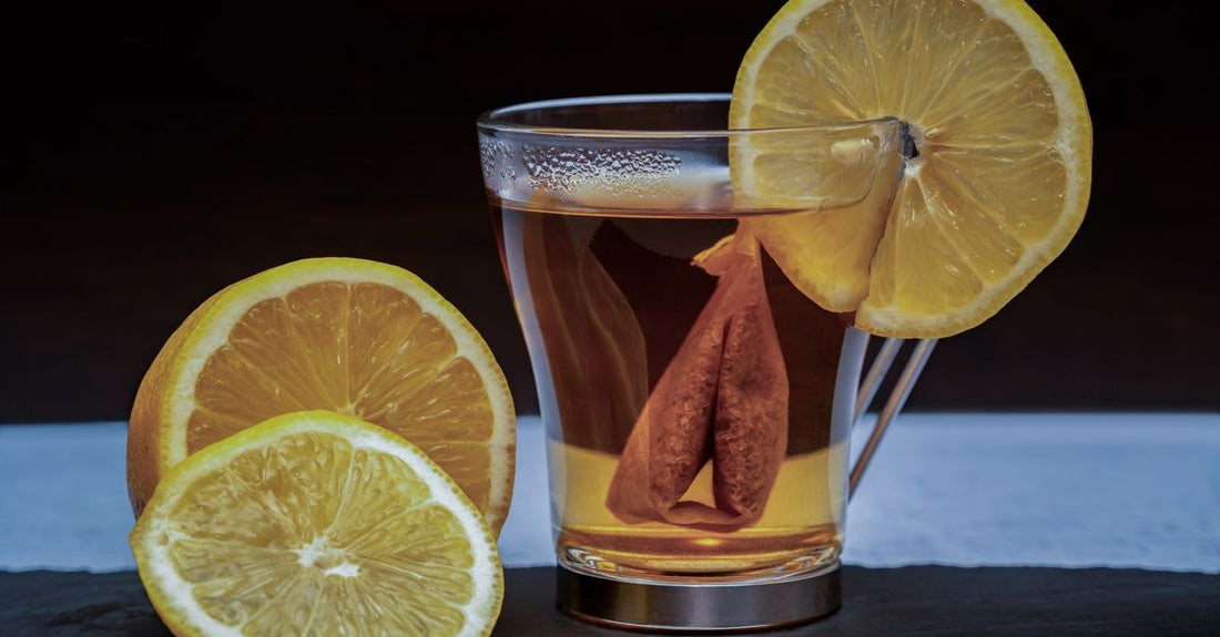 A glass of water with lemon slices next to fresh alkaline foods, representing the Viva Mayr diet plan explained for digestive health.