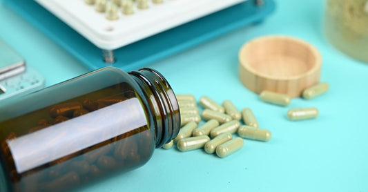A glass bottle of stress support supplement with ashwagandha capsules on a clean white surface, reflecting natural light.