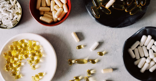A selection of whole food multivitamin capsules and a bottle on a light background, representing the best whole food multivitamin for women 50+.