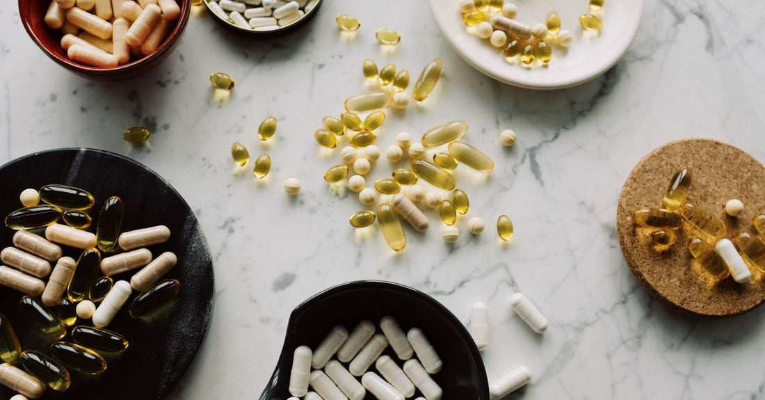 A flatlay of various vitamin and mineral supplement bottles for immune support on a light background, representing the best immune support supplements UK 2026.