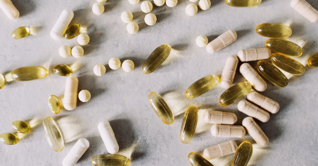 Vitamin D3 supplement capsules and a glass of water on a white surface, illustrating how to choose vitamin D3 dosage for adults.