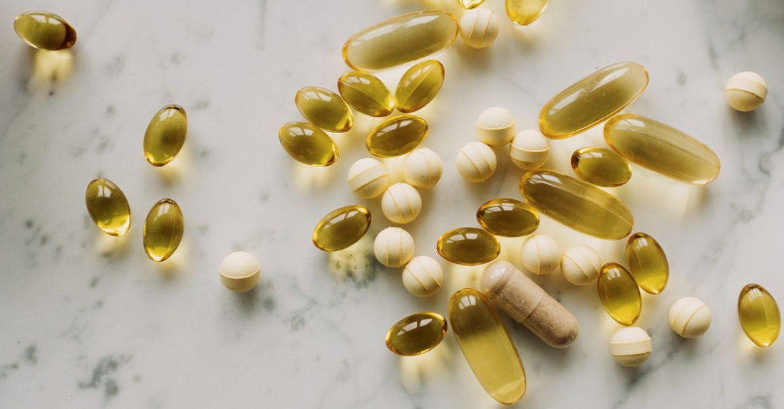 Assorted vitamin supplement pills and capsules in a flat lay arrangement, representing vitamins for vitality