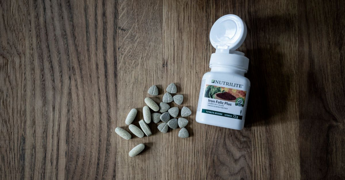 Bottle of folate 5 mg supplement capsules on a white background, with a focus on the label.