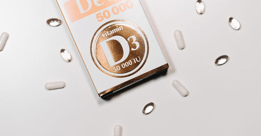 Bottles of vitamin D3 and K2 capsules on a clean white surface, illustrating the popular combined supplement for bone and heart health.