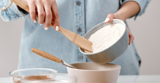 Bowl of Wanka Foods organic maca powder with a wooden spoon on a rustic table