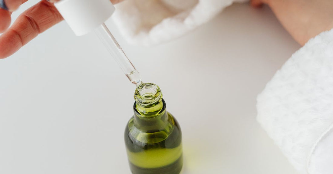 A glass dropper bottle of Brazilian green propolis extract for oral health on a neutral background.