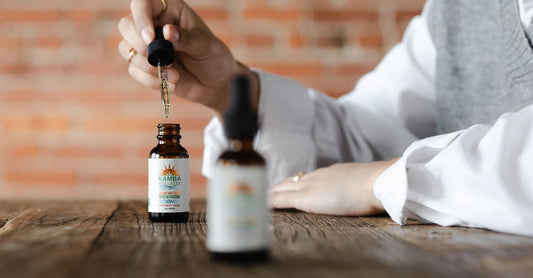 A glass bottle of sub lingual B12 supplement with a dropper on a white surface, showing the liquid's natural colour.