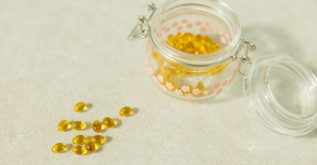 A bottle of CoQ10 supplements on a clean white background, with soft-gel capsules scattered nearby, illustrating coq10 for blood pressure support.
