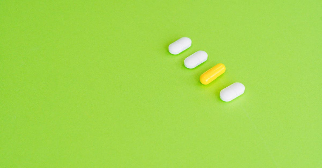 A selection of the best serotonin and dopamine supplements in capsule form, arranged on a clean white surface with a measuring tape, symbolising precise, informed choices.
