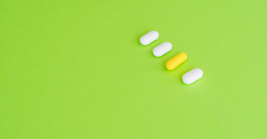 A selection of the best serotonin and dopamine supplements in capsule form, arranged on a clean white surface with a measuring tape, symbolising precise, informed choices.